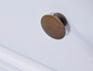 Een wit houten meubel met een ronde messing knoppen