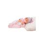 Babypop in roze onesie met muts en speen, liggend op een wit kussen.