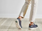 Mannen dragen blauwe sneakers met witte zolen.