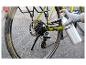 Hand in handschoen smeert een fietsketting met een spuitfles.