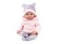 Babypop met een roze hoodie en een bedrukte broek met bijpassende muts.