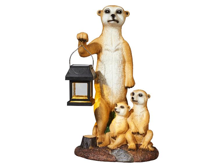 Decoratieve figuur van een stokstaartjesfamilie, waarbij het volwassen dier een zonnelantaarn vasthoudt.