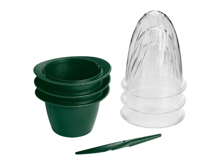 Een set groene potten met doorzichtige deksels en een tuingereedschap.