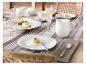 Elegante tafelsetting met wit porseleinen servies, champagneglazen en desserts.