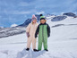 Twee kinderen in winterkleding in de sneeuw.