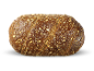 Een volkorenbrood met zaden op een zwarte achtergrond.