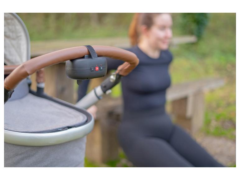Vrouw sport buiten met kinderwagen en bevestigd ZAZU-apparaat.