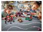 Twee kinderen spelen met LEGO Speed Champions sets, waaronder een transporttruck en raceauto's.