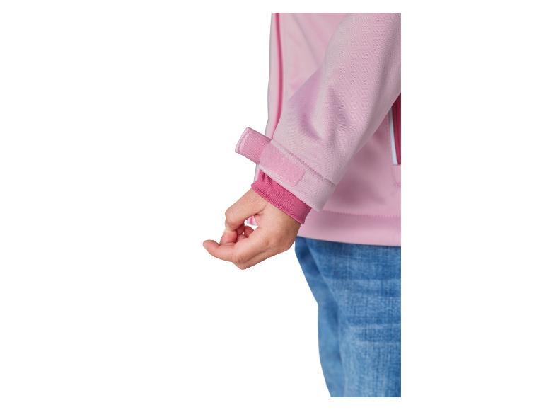Mouw van roze softshelljack met klittenbandsluiting en elastische manchet, gedragen met jeans.