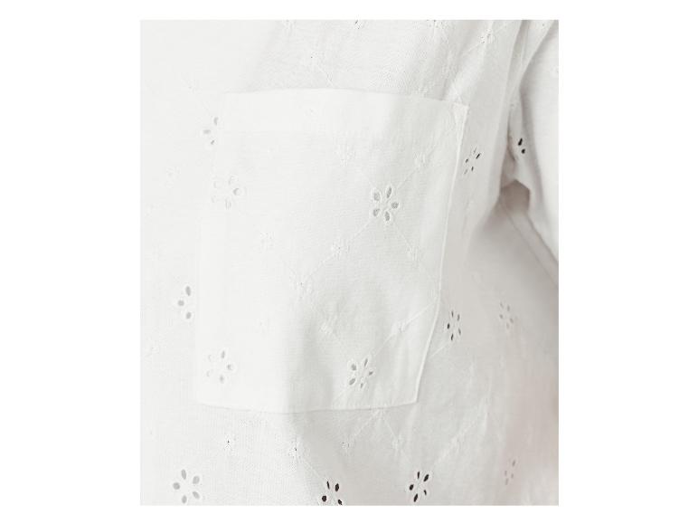Detail van een wit broderie anglaise overhemd met borstzak.