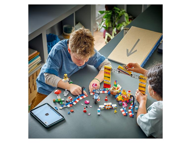 Twee kinderen spelen met een LEGO Super Mario Kart set op een tafel.