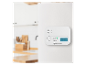 Witte gasdetector met digitaal display en knoppen, gemonteerd op een witte muur in een keuken.