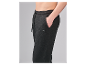 Close-up van een persoon die een zwarte joggingbroek draagt met een trekkoord en een klein label.