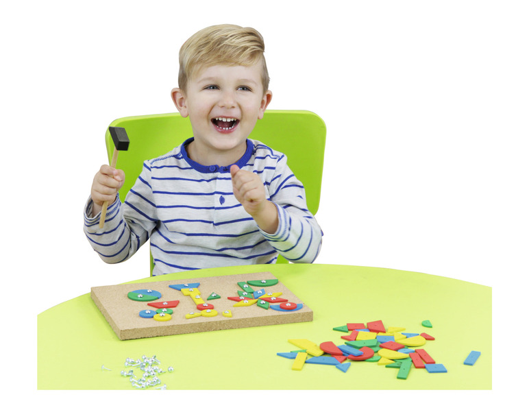 Een kind speelt met houten vormen en een hamer.