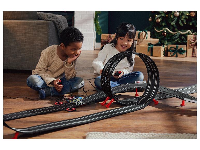 Twee kinderen spelen met een Carrera racebaan met een politieauto.