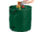 Groene tuinafvalzak met herfstbladeren en gehandschoende handen