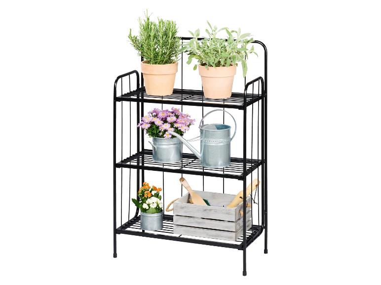 Zwart metalen drielaags rek met kruiden, bloemen en tuingereedschap.