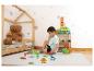 Jongen speelt met magnetische bouwblokken en dinosaurusfiguren op een speelmat in een kinderkamer.