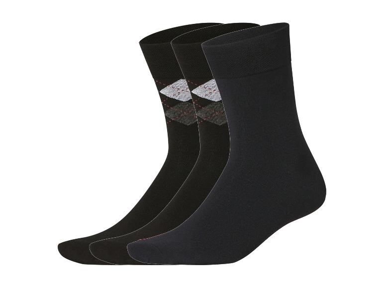 Drie paar zwarte sokken, één met argylepatroon.
