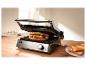 Grill met een sandwich erin en geroosterd brood op een bord ernaast.