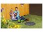 Koppel ontspant op gras met tuinlaarzen en een tuinputdeksel.