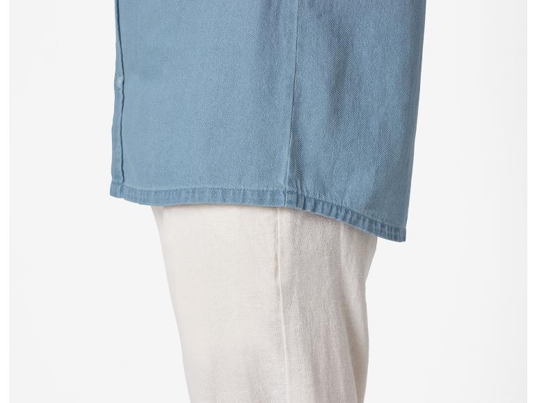 Lichtblauw denim overhemd en lichtbeige broek.