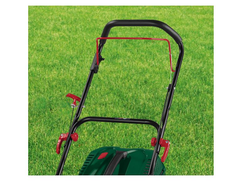 Handvat van grasmaaier met rode hendels op groen gazon