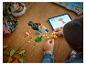 Een kind bouwt een LEGO Creator 3-in-1 papegaai, de instructies volgend op een tablet.
