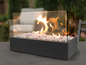 Een moderne buitenhaard met een glazen omkasting en witte stenen.