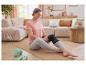 Vrouw in de woonkamer op een fitnessmat met een Sensiplast kniebandage.