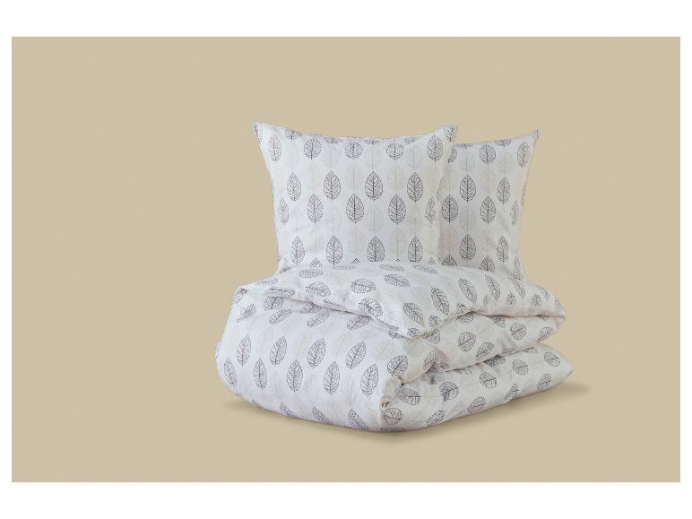 Wit beddengoedset met een patroon van bruine en beige bladeren.
