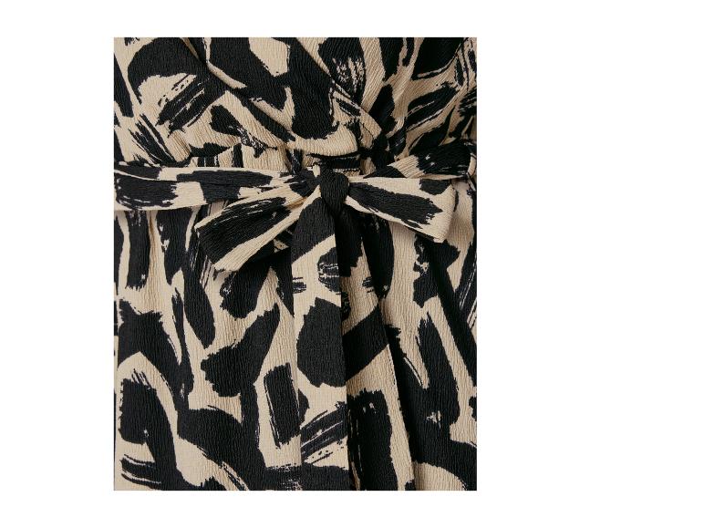 Detail van een damesjurk met een abstracte zwart-beige print.