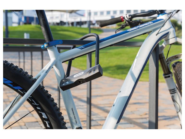 Mountainbike met een grijs U-slot, vastgemaakt aan een fietsenrek