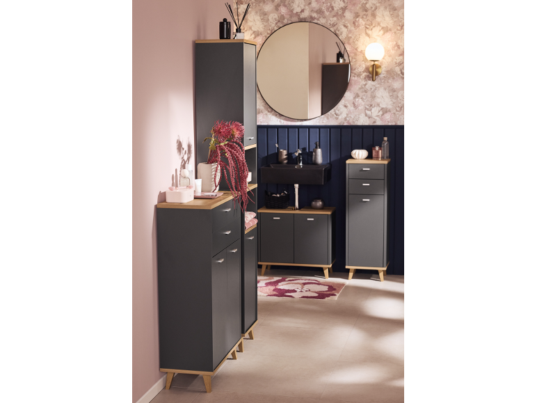 Moderne badkamer met grijze meubels en houten bladen, zwarte wastafel, ronde spiegel en bloemenbehang.