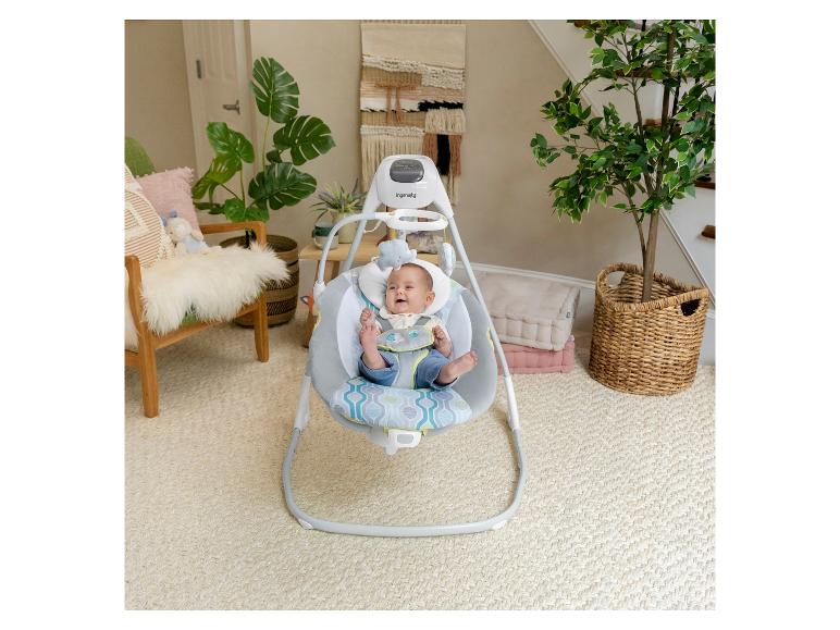 Babywieg met blije baby in woonkamer