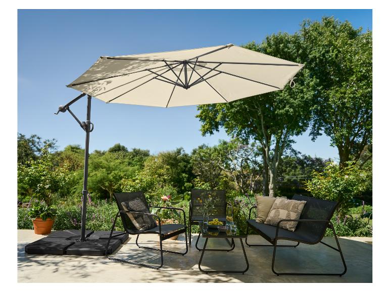 Tuinmeubelset met parasol, twee stoelen, een bankje en een tafel in een tuin.
