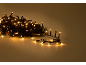Kerstverlichting met warme LED-lampjes op een effen achtergrond.