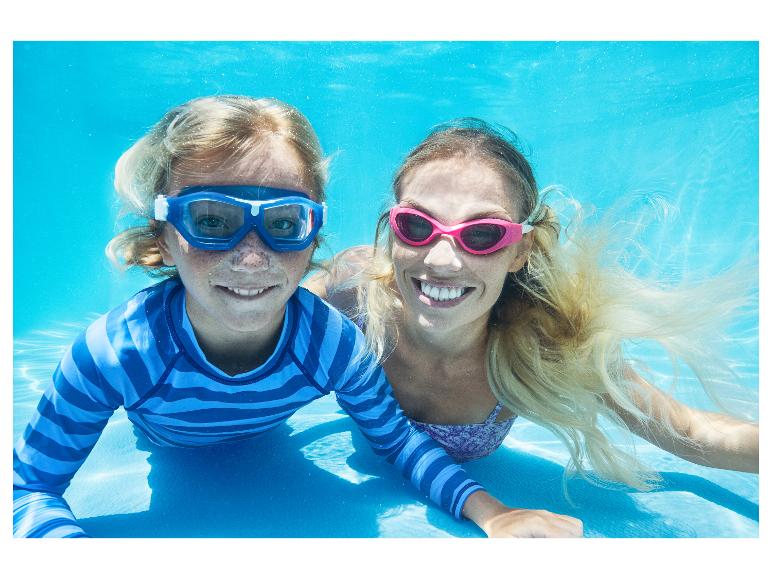 Twee mensen in zwembrillen en badkleding onder water, lachend naar de camera.