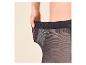 Vrouw trekt aan de tailleband van een zwarte panty om de elasticiteit te tonen.