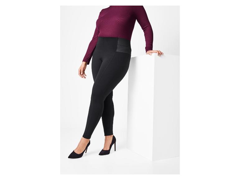 Vrouw in zwarte leggings en bordeauxrode trui.