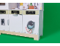 Houten speelgoedkeuken voor kinderen met een wasmachine op een groene achtergrond.