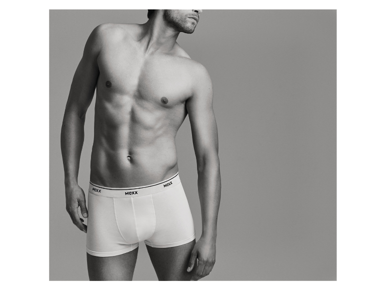 Een man toont witte boxershorts van MEXX.