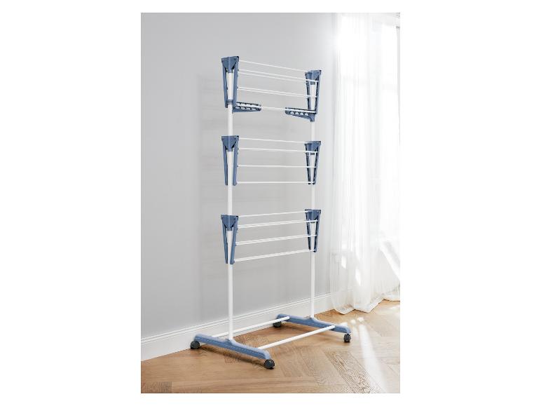 Droogrek op wielen, blauw en wit, bij een raam