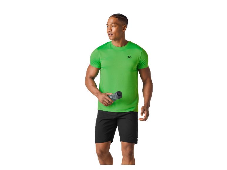 Man in een groen sportshirt en zwarte korte broek, met een waterfles.