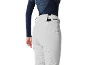 Vrouw in lichtgrijze skibroek en een donkerblauw shirt met lange mouwen.
