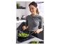 Vrouw bakt broccoli in een koekenpan op een inductiekookplaat in de keuken.