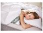 Vrouw slaapt in bed met wit dekbed en kussen, dekbedlabel toont 'fjödur'.