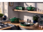 Groene gietijzeren pannenset op een houten keukenblad en plank.