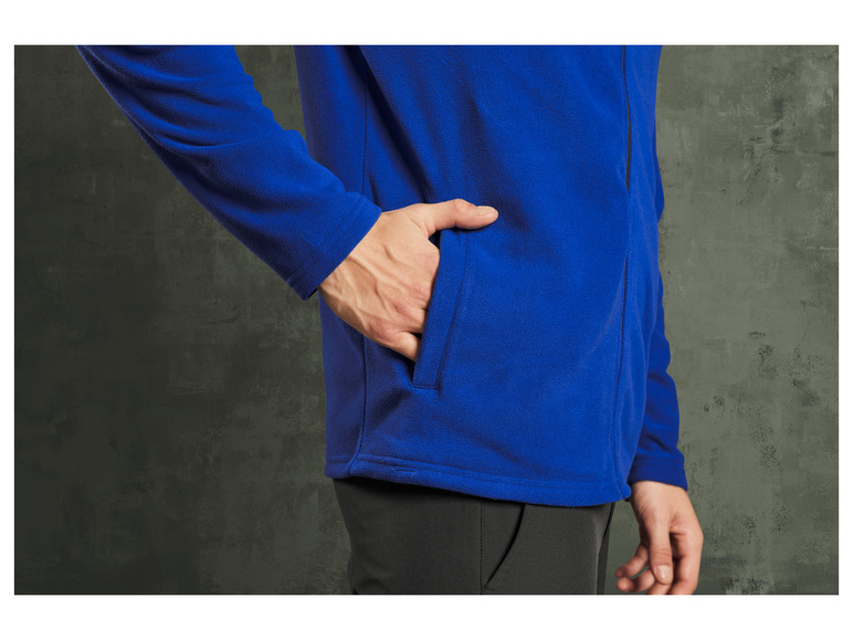 Man in een blauwe fleece trui met een zak