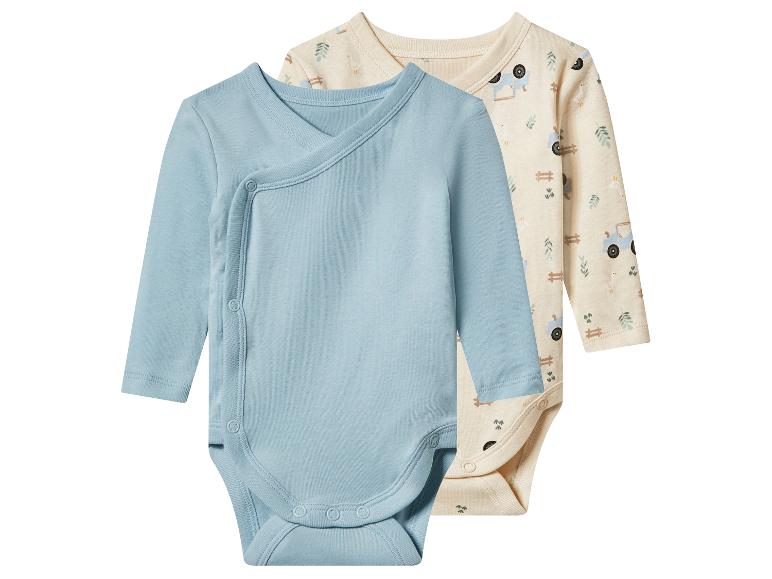 Twee rompertjes met lange mouwen: één lichtblauw overslagmodel en één beige met boerderijpatroon.